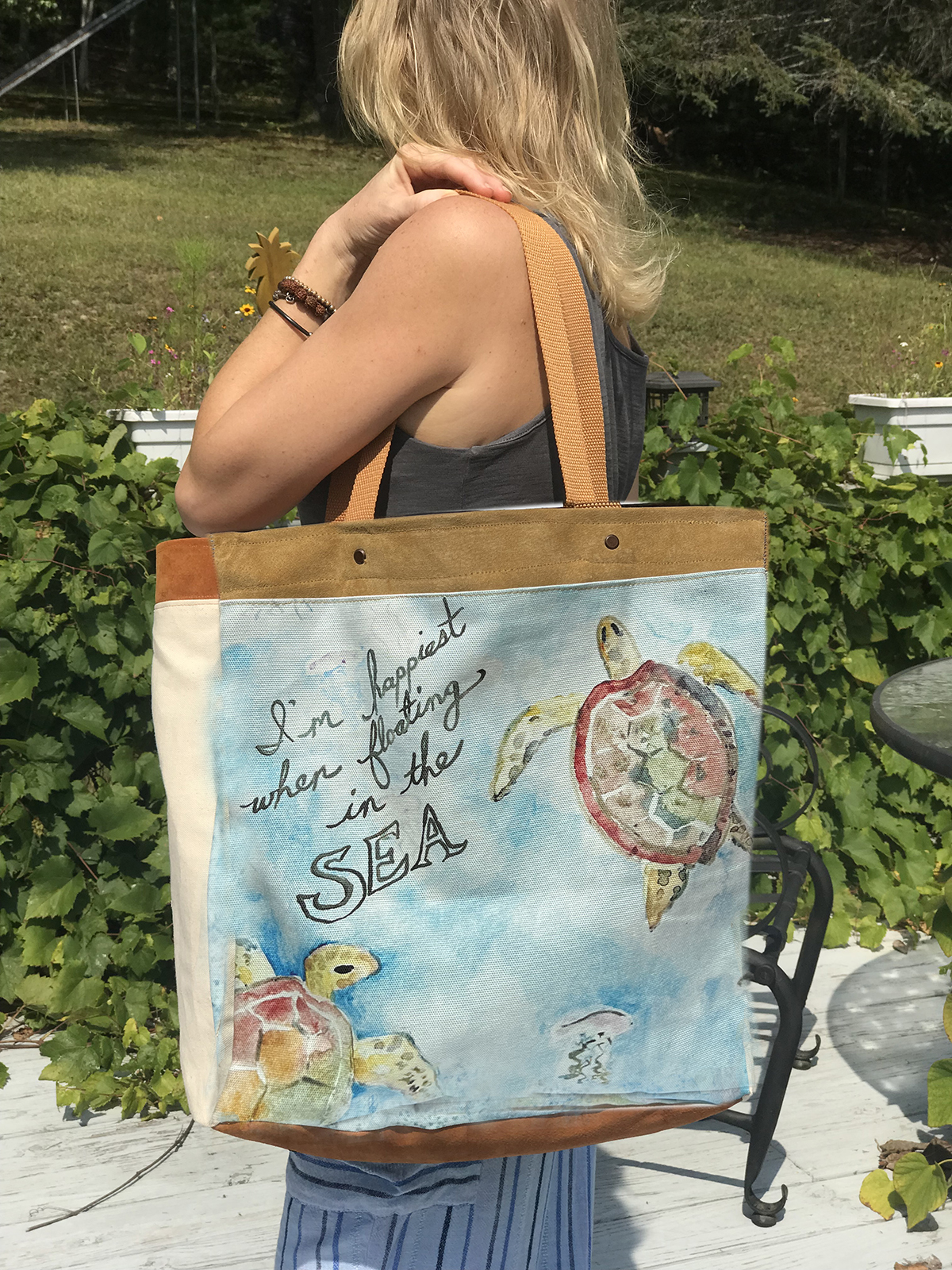 This Sea Turtle Beach Bag features a whimsical watercolor painting of Turtles swimming in the sea. This tote will hold everything you need for the beach.